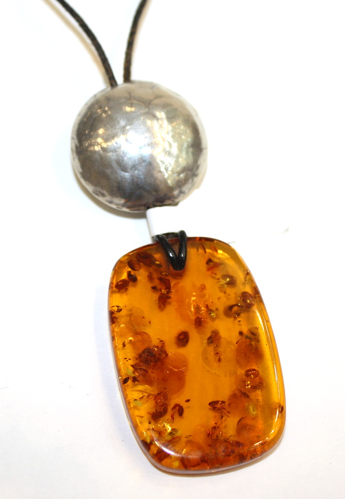 Baltic Amber pendant- irregular piece below silver disc on leather thong-